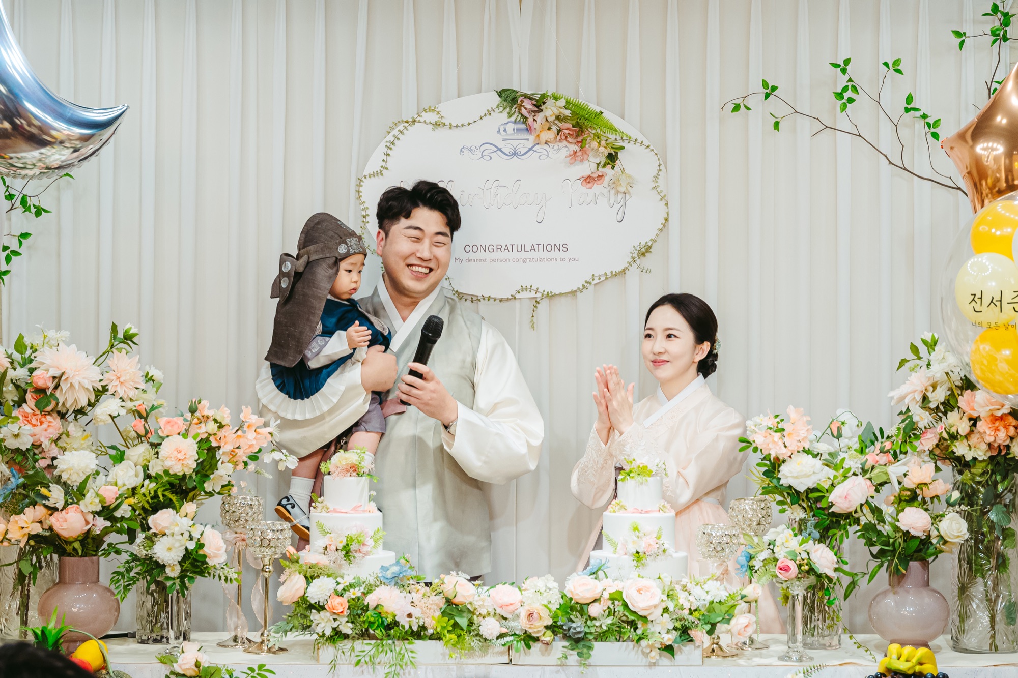 돌잔치 무대에서 아기를 안은 아빠와 엄마