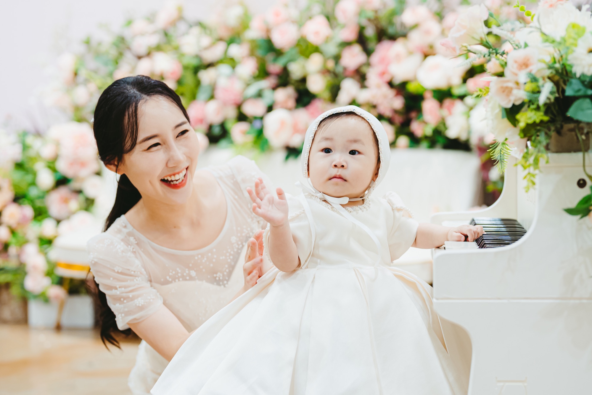 꽃 앞에서 아기와 함께 웃는 엄마