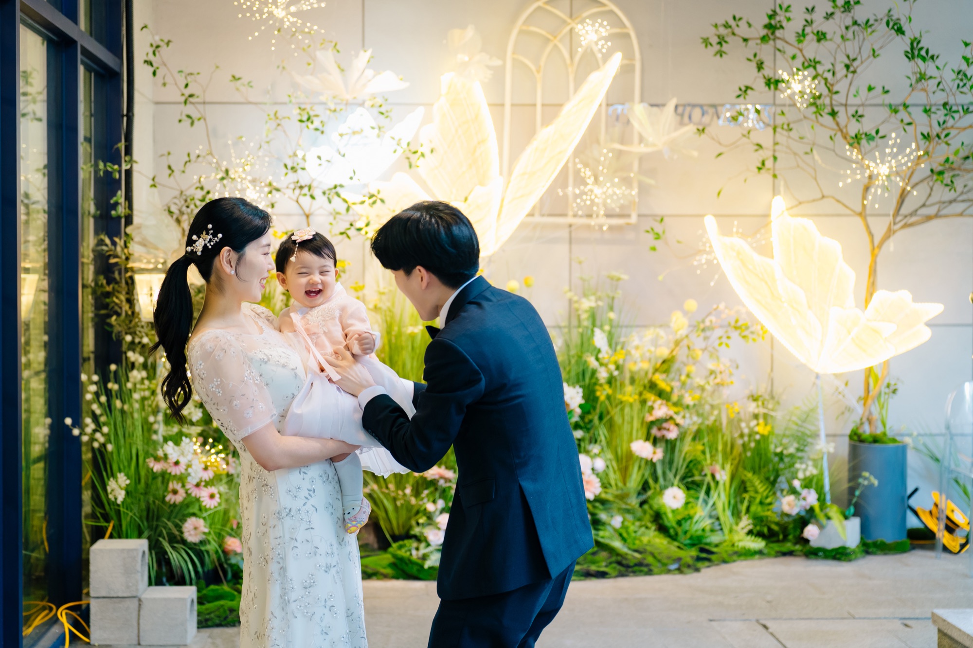 화사한 꽃 장식 앞에서 함께 웃는 가족